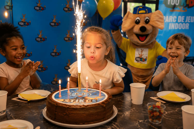 Petite fille soufflant les bougies de son gâteau d'anniversaire chez You Kids Thiverval Liberty
