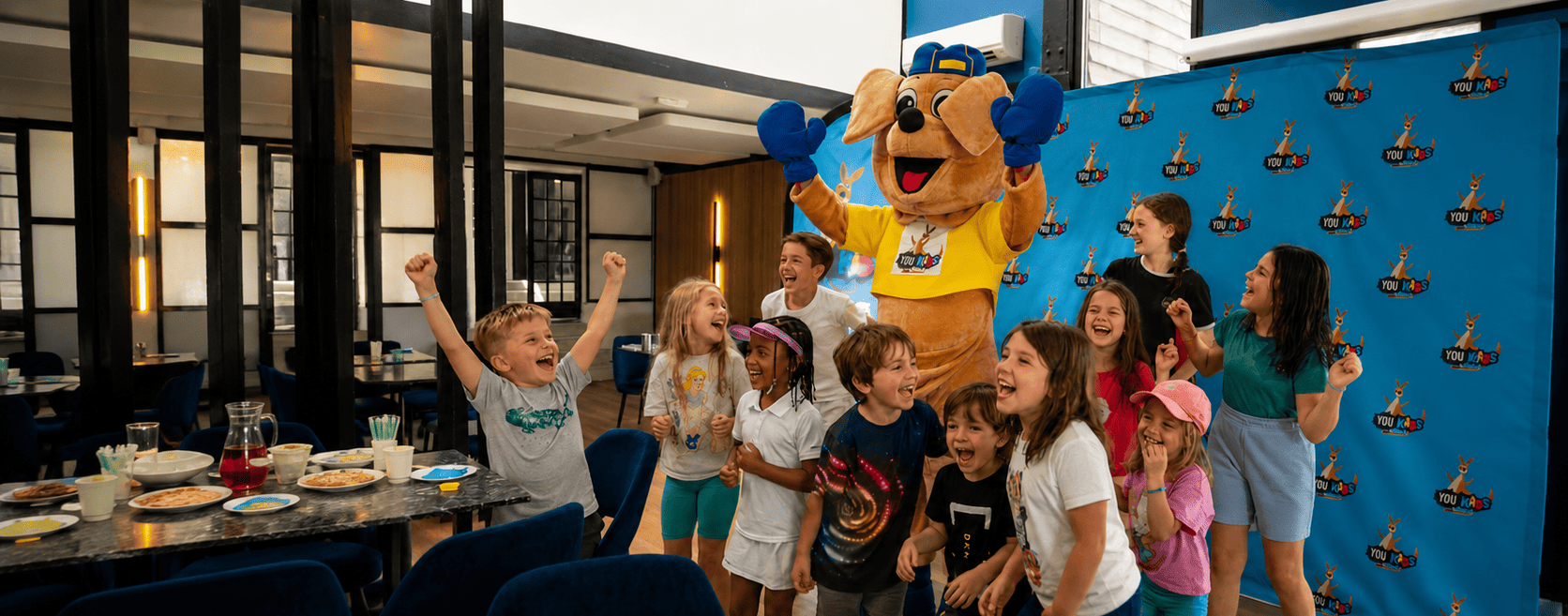 Groupe d'enfants avec la mascotte You Kids lors d'un événement à Thiverval Liberty