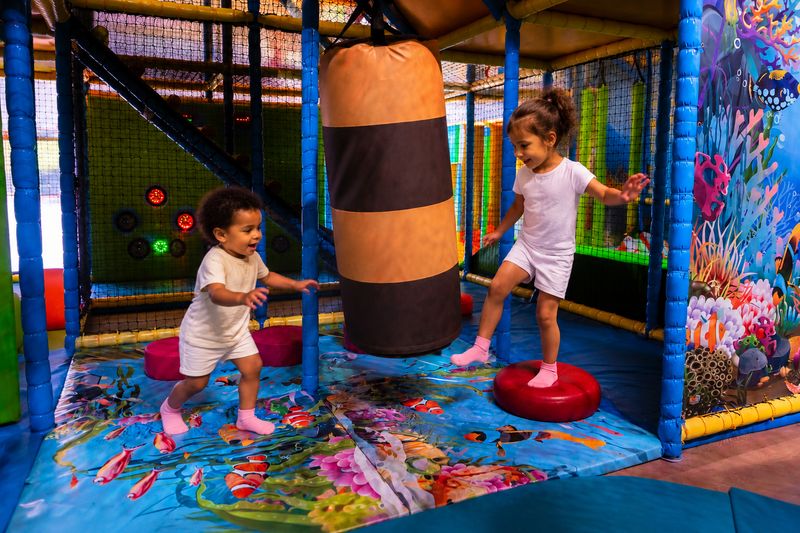 Enfants jouant autour du sac de frappe chez You Kids Thiverval Liberty